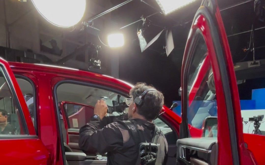 Camarógrafo grabando una camioneta dentro del estudio